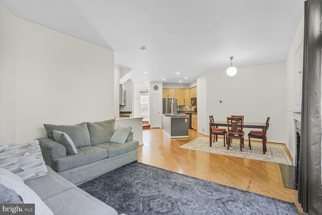 living room with light wood-style flooring and recessed lighting