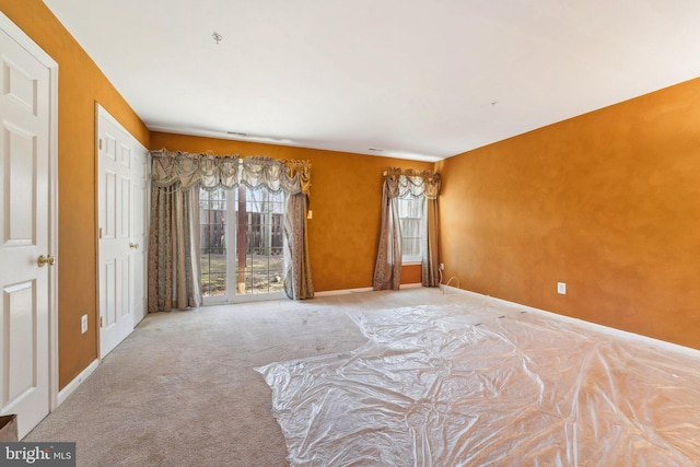 unfurnished bedroom featuring access to exterior, baseboards, and carpet floors