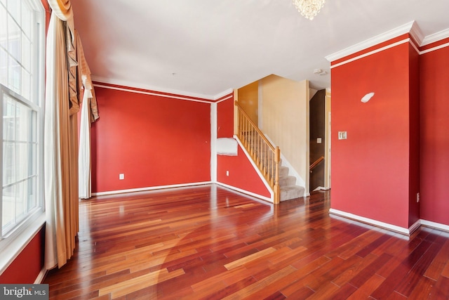 foyer with baseboards, wood finished floors, stairs, and crown molding