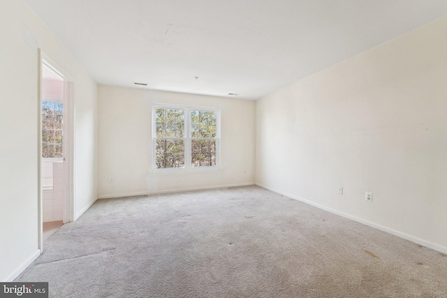 carpeted spare room featuring baseboards