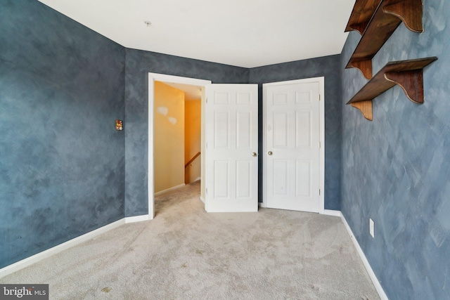 unfurnished bedroom featuring baseboards and carpet flooring