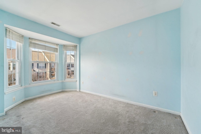 empty room featuring visible vents, baseboards, and carpet flooring