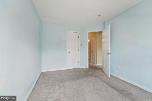 unfurnished bedroom with baseboards and carpet