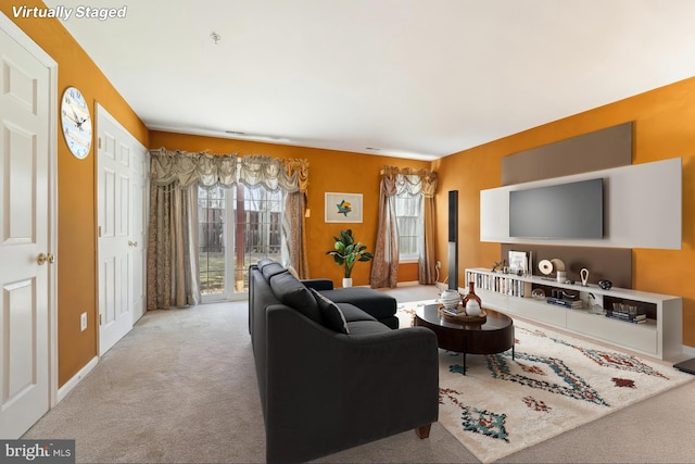 carpeted living area featuring baseboards