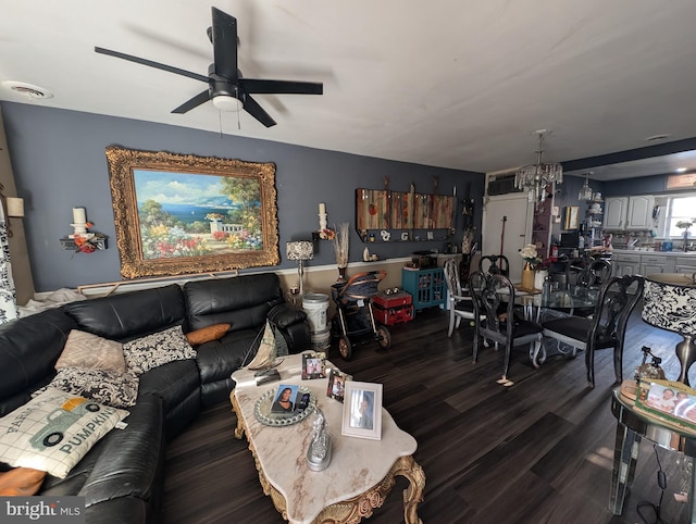 living room featuring ceiling fan with notable chandelier, wood finished floors, and visible vents