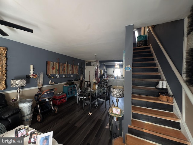 interior space with wood finished floors and ceiling fan with notable chandelier