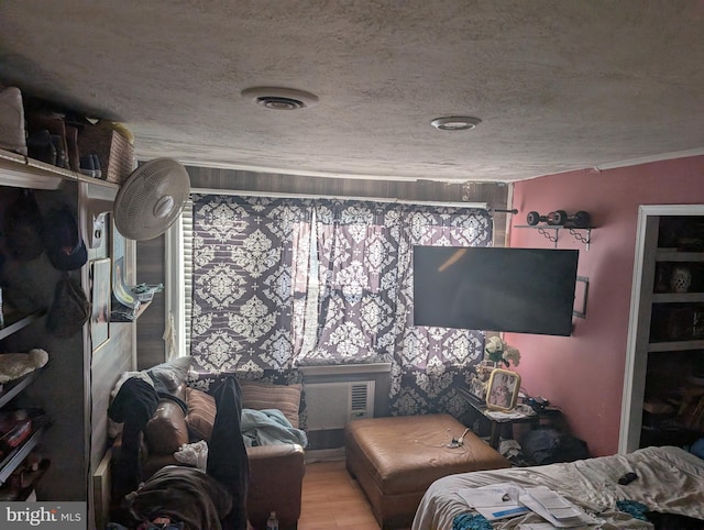 bedroom featuring wood finished floors, visible vents, and a textured ceiling