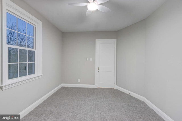 carpeted empty room featuring baseboards and ceiling fan