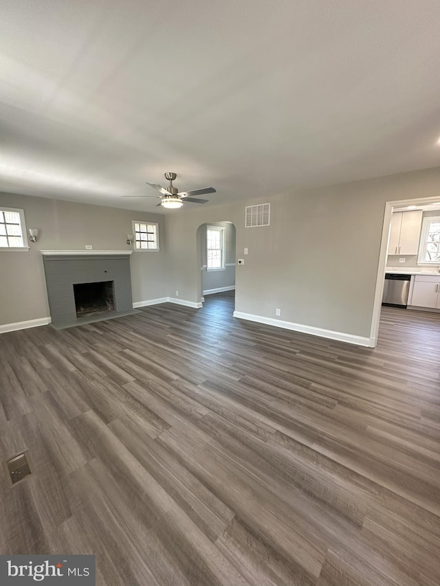 unfurnished living room featuring visible vents, baseboards, a healthy amount of sunlight, and a fireplace