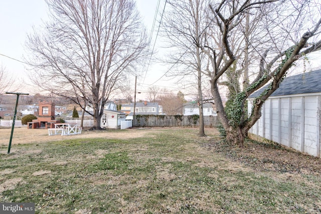 view of yard featuring an outdoor structure and fence