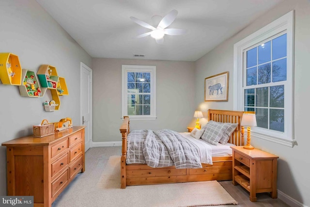 bedroom featuring visible vents, baseboards, light colored carpet, and ceiling fan