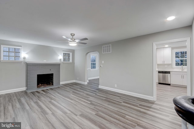 unfurnished living room featuring visible vents, baseboards, light wood-style flooring, and a fireplace