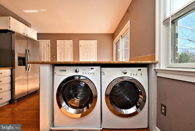 laundry room with washer and dryer, wood finished floors, and laundry area