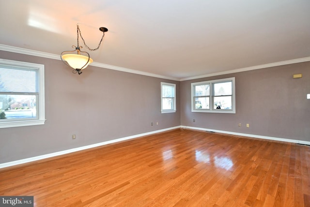 spare room featuring light wood-style flooring, baseboards, and ornamental molding