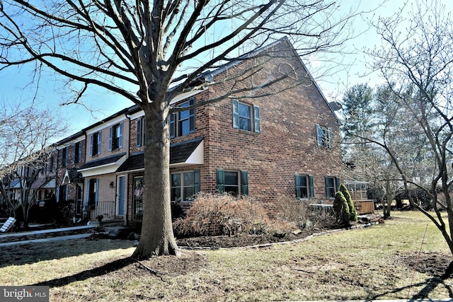 view of front of home featuring brick siding and a front lawn