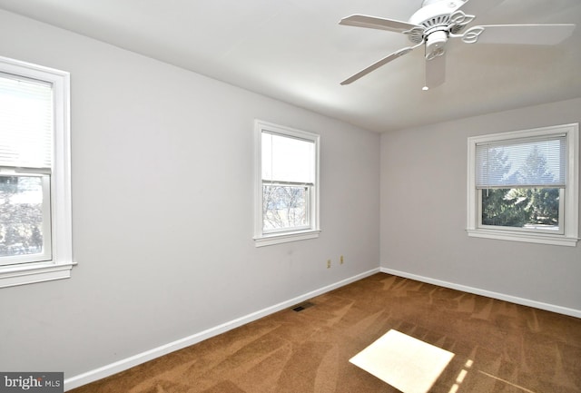 empty room with a ceiling fan, carpet, visible vents, and baseboards