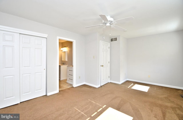 unfurnished bedroom with visible vents, baseboards, carpet floors, ensuite bathroom, and a closet