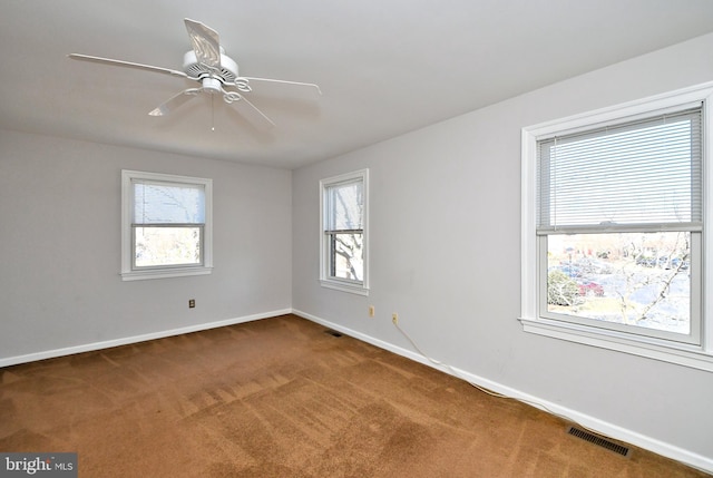 spare room featuring visible vents, carpet flooring, baseboards, and ceiling fan