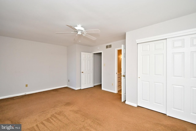 unfurnished bedroom featuring visible vents, a closet, carpet floors, baseboards, and ceiling fan