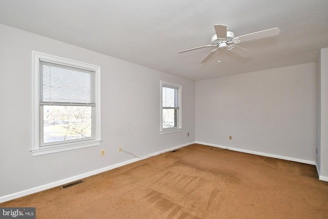 unfurnished room featuring visible vents, carpet flooring, a ceiling fan, and baseboards