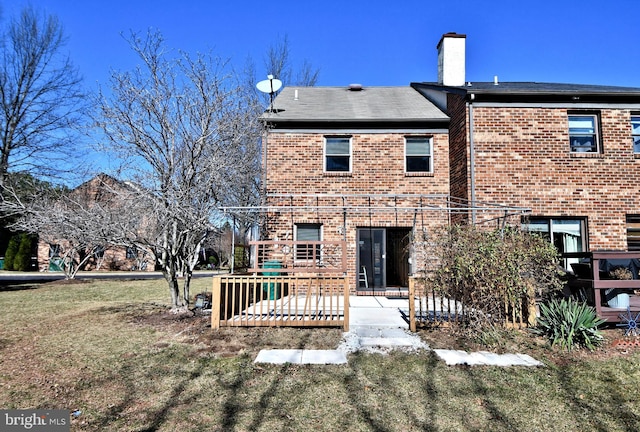 back of property with a yard, a patio area, brick siding, and a chimney