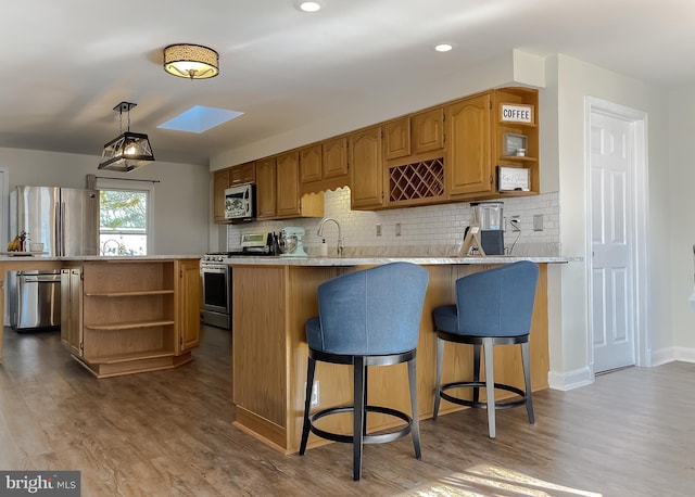 kitchen with open shelves, a peninsula, light countertops, and stainless steel appliances