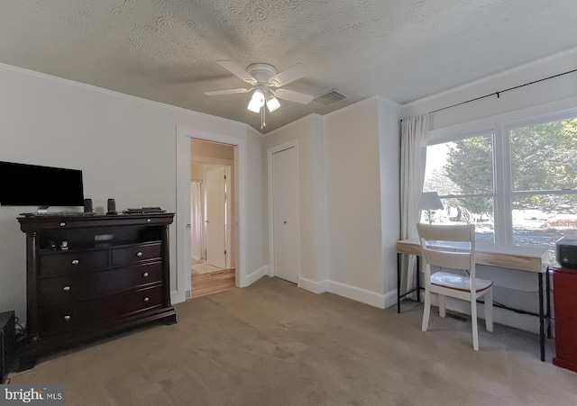 office space featuring a textured ceiling, visible vents, ceiling fan, light carpet, and crown molding