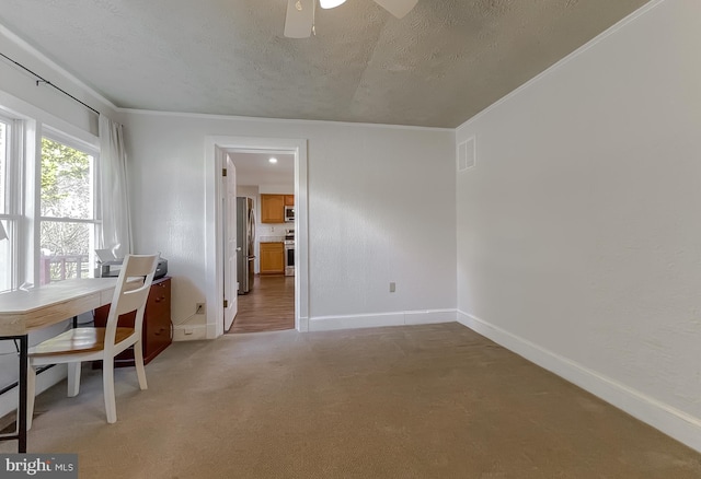 unfurnished office with visible vents, baseboards, light colored carpet, a textured ceiling, and a ceiling fan