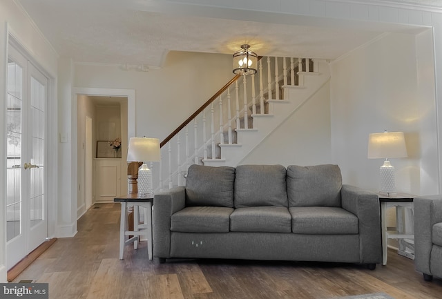 living area with stairway, ornamental molding, and wood finished floors