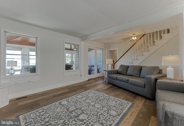 living room with visible vents, baseboards, stairs, wood finished floors, and a textured ceiling