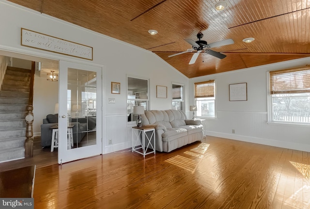 unfurnished living room with wood finished floors, wooden ceiling, wainscoting, lofted ceiling, and ceiling fan