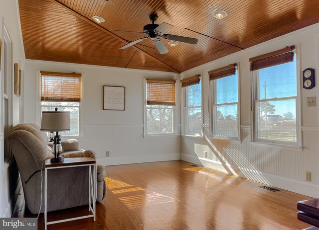 interior space featuring a wealth of natural light, wooden ceiling, and wainscoting