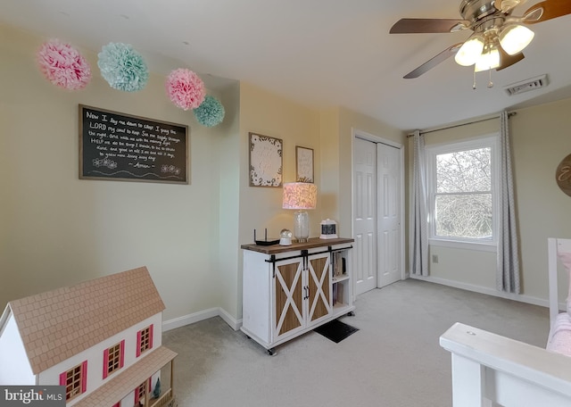 interior space featuring visible vents, baseboards, carpet, and ceiling fan