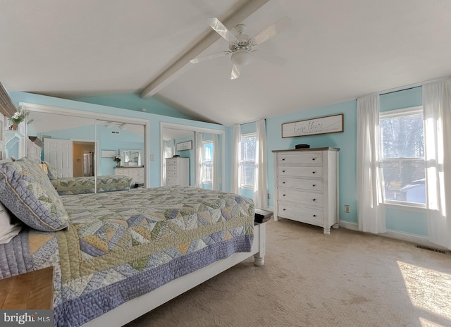 carpeted bedroom with baseboards, visible vents, vaulted ceiling with beams, and ceiling fan