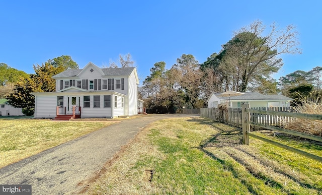 view of front of home with a front yard and fence