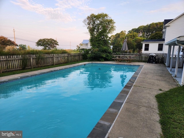 view of swimming pool featuring a fenced in pool, a patio area, and fence