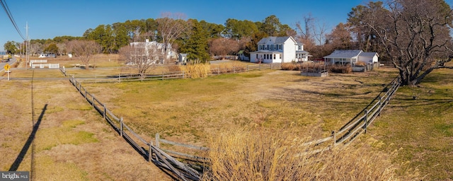 view of yard featuring a rural view, an outbuilding, and fence