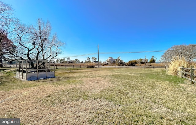 view of yard with a rural view and fence