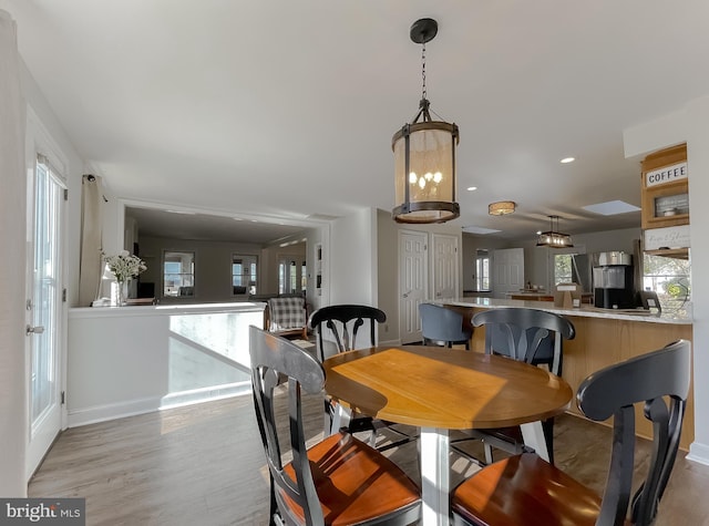 dining space with recessed lighting, baseboards, and light wood finished floors