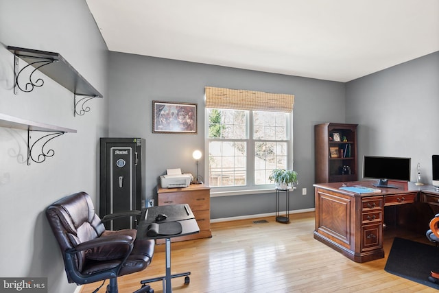 office space featuring visible vents, light wood-style floors, and baseboards