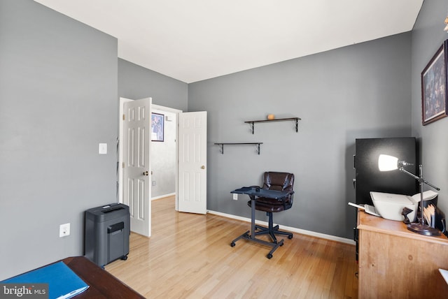 office with baseboards and light wood-style floors