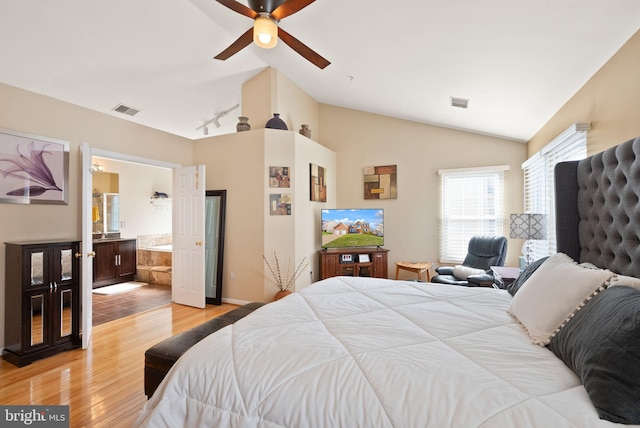 bedroom featuring visible vents, lofted ceiling, light wood-style floors, and track lighting