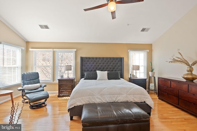 bedroom with visible vents, ceiling fan, light wood-style floors, and vaulted ceiling