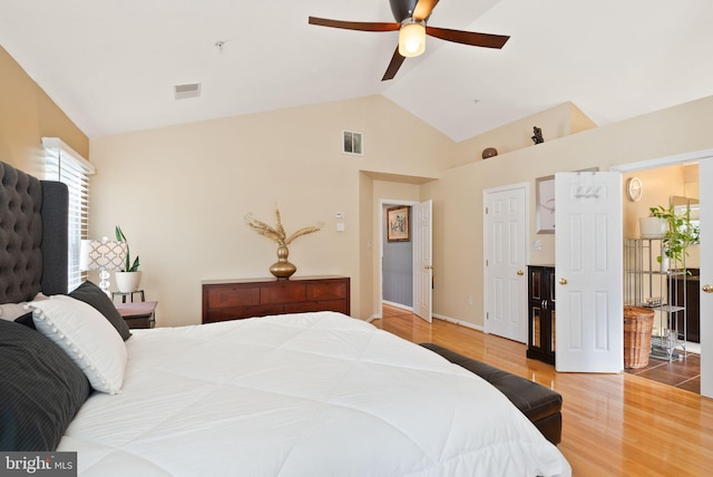 bedroom with wood finished floors, visible vents, baseboards, high vaulted ceiling, and ceiling fan