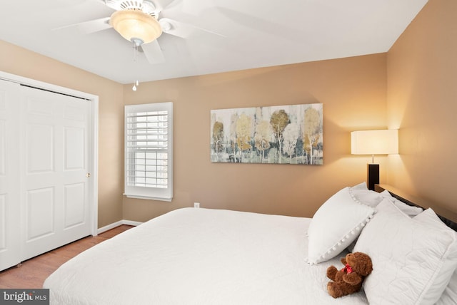 bedroom with ceiling fan, baseboards, and wood finished floors