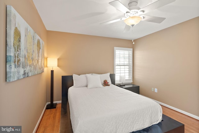 bedroom with ceiling fan, baseboards, and wood finished floors