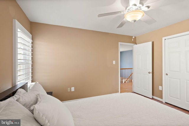 bedroom featuring baseboards, a ceiling fan, and wood finished floors