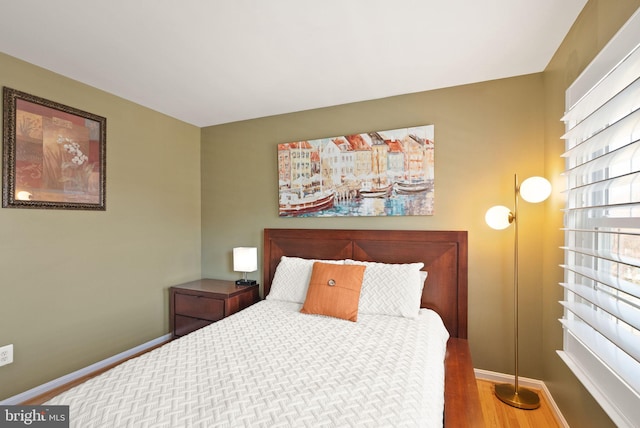 bedroom featuring baseboards and wood finished floors