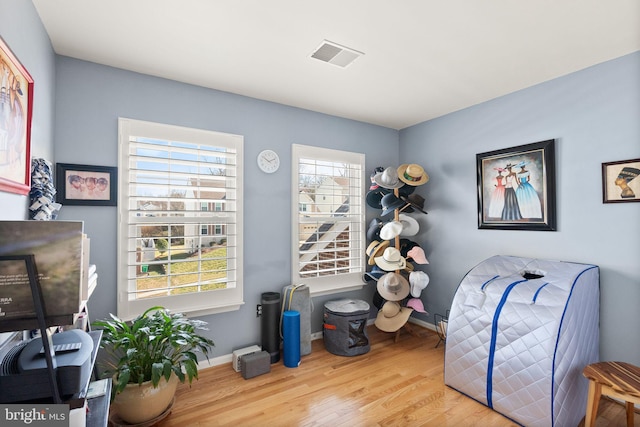 miscellaneous room with a wealth of natural light, visible vents, baseboards, and wood finished floors