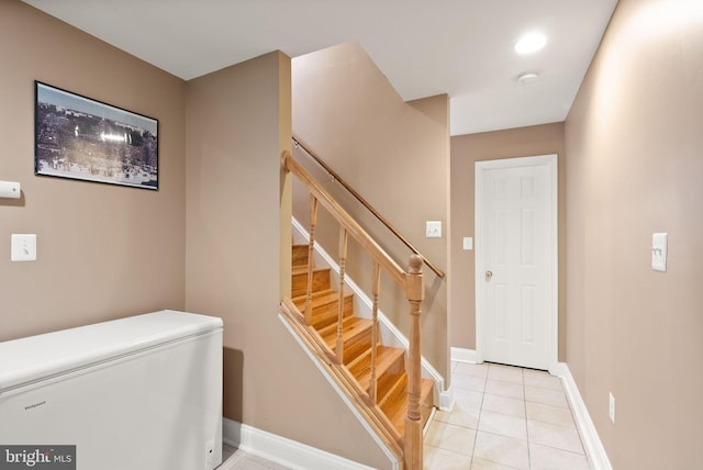 stairway with tile patterned floors and baseboards